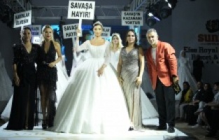 İzmir’de defileye çıkan Özge Ulusoy, “Savaşa Hayır” yazılı pankart açtı